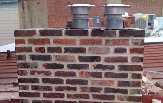 Chimney with historic masonry and tuckpointing restoration in progress.