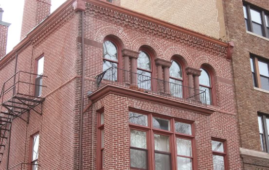 Historic brick building with ornate masonry and large arched windows.