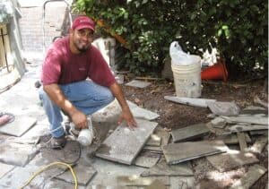 A smiling Renaissance Development worker preparing a site for a patio build.