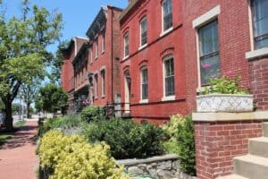 Well-maintained historic brick rowhouses in Washington, DC, with restored masonry façades and landscaped front gardens.