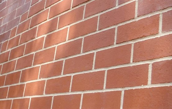 Close-up of historic brick masonry with tuckpointing work on a building wall.