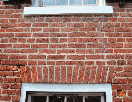 Close-up of historic brick masonry and tuckpointing work on a building facade.