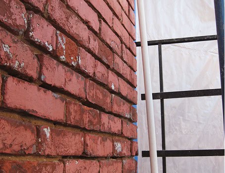 Close-up of historic brick masonry with tuckpointing work in progress.