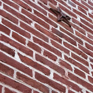 Close-up of historic brick wall with star-shaped ornament.