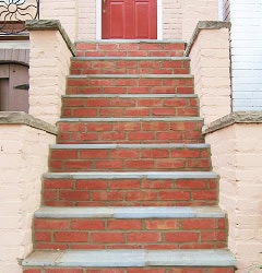 Restoration of historic brick masonry and tuckpointing on a classic building staircase. Expert craft.