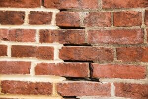 Close-up of historic brick masonry with tuckpointing and cracks.