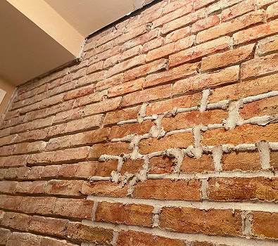 Close-up of historic brick wall with tuckpointing and masonry work.