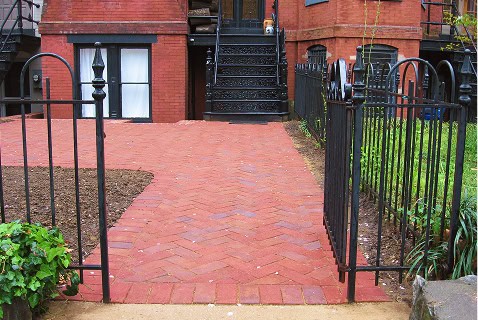 Historic brick pathway with restored masonry and tuckpointing in a residential area.