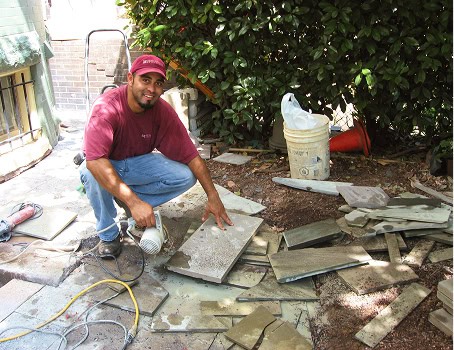 Mason inspecting and working on historic masonry and tuckpointing restoration.