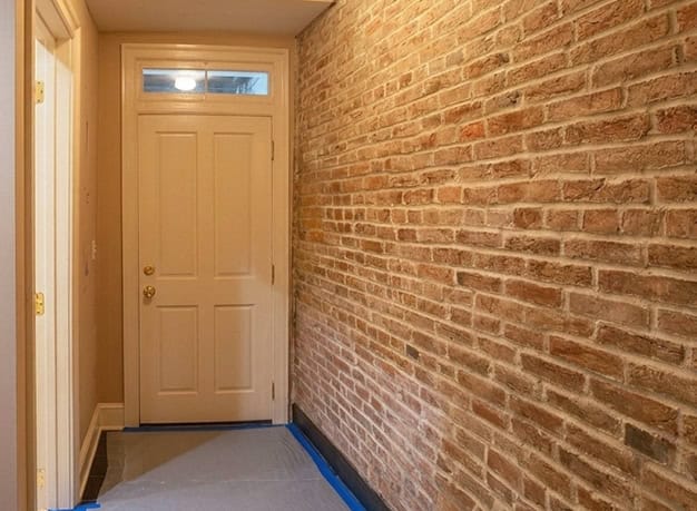 Brick wall with detailed tuckpointing in a historic building.