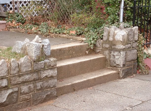 Historic stone steps with masonry and tuckpointing work in a residential setting.