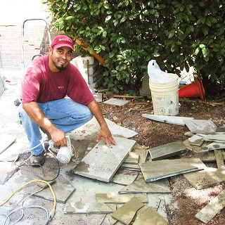 Man working on historic masonry and tuckpointing project outdoors.