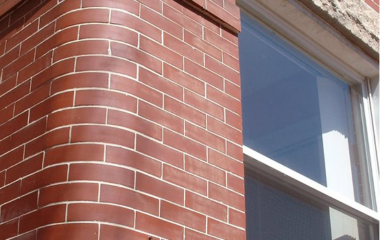 Close-up of historic brick masonry and tuckpointing on a building exterior.