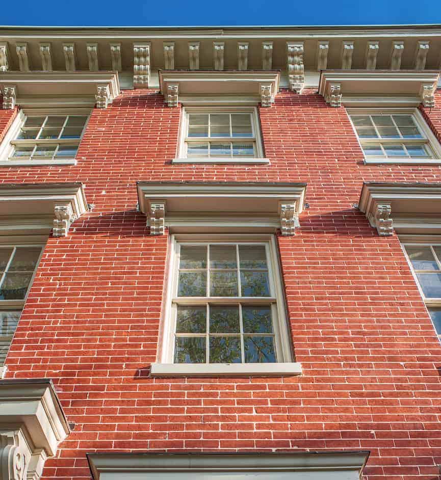 Renaissance Development Brick Masonry Restoration Close-up of a historic red brick building with detailed masonry and window trim.