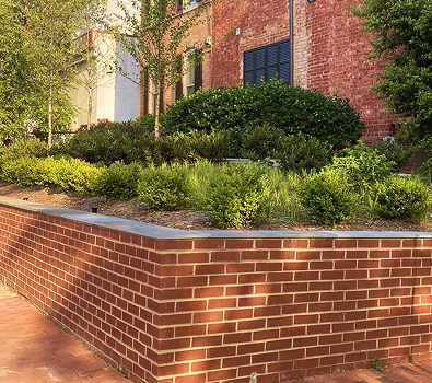patio and walkways img 12 Brick building with raised planter and green shrubs