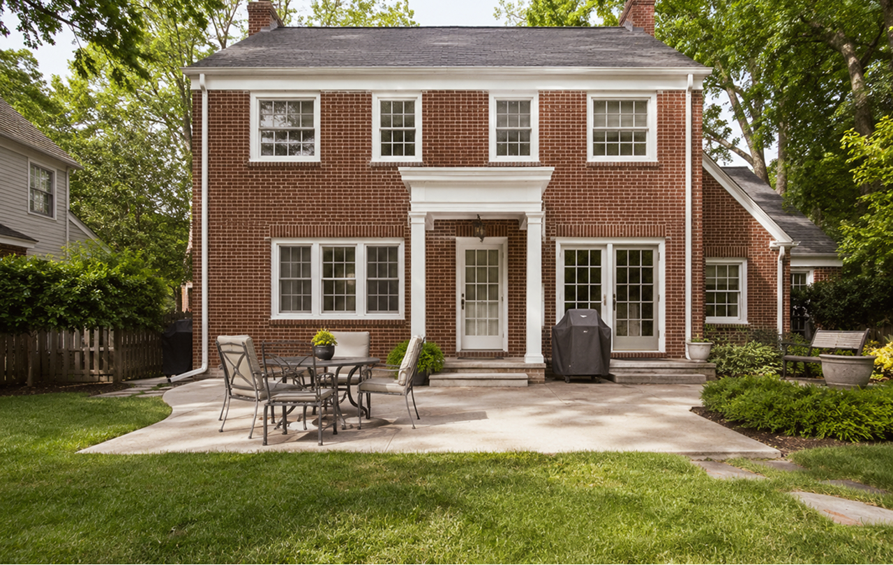 Two-story brick house with backyard patio and lawn